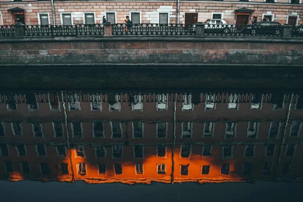 Old multistage building facade reflecting in urban canal